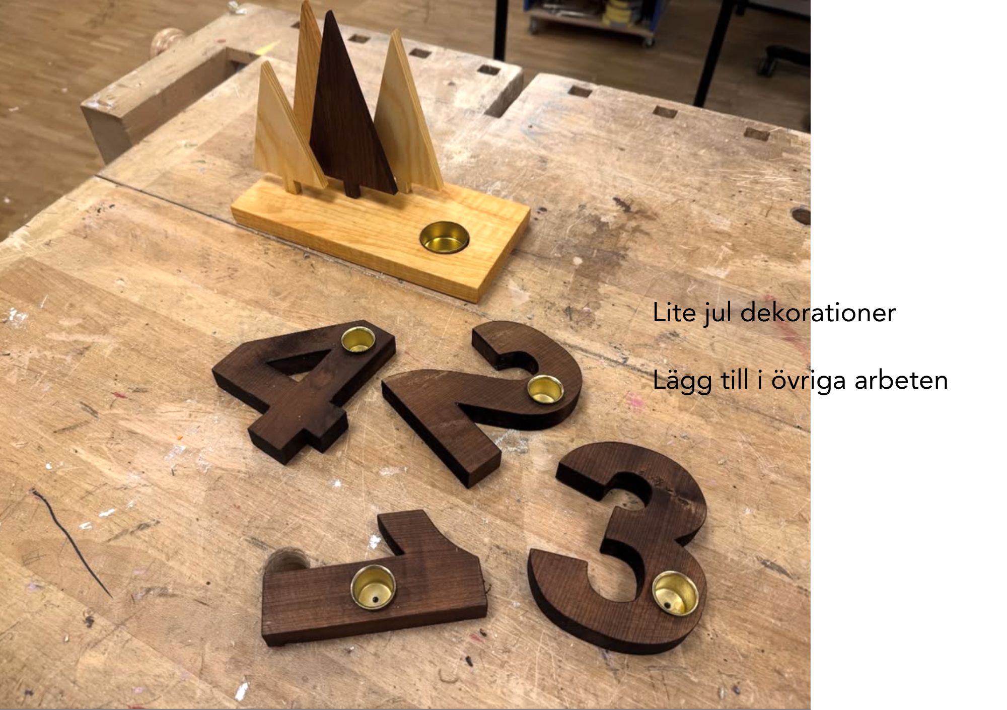 Adventsljusstakar i trä formade som siffrorna 1–4 och granar med mässingskoppar för värmeljus