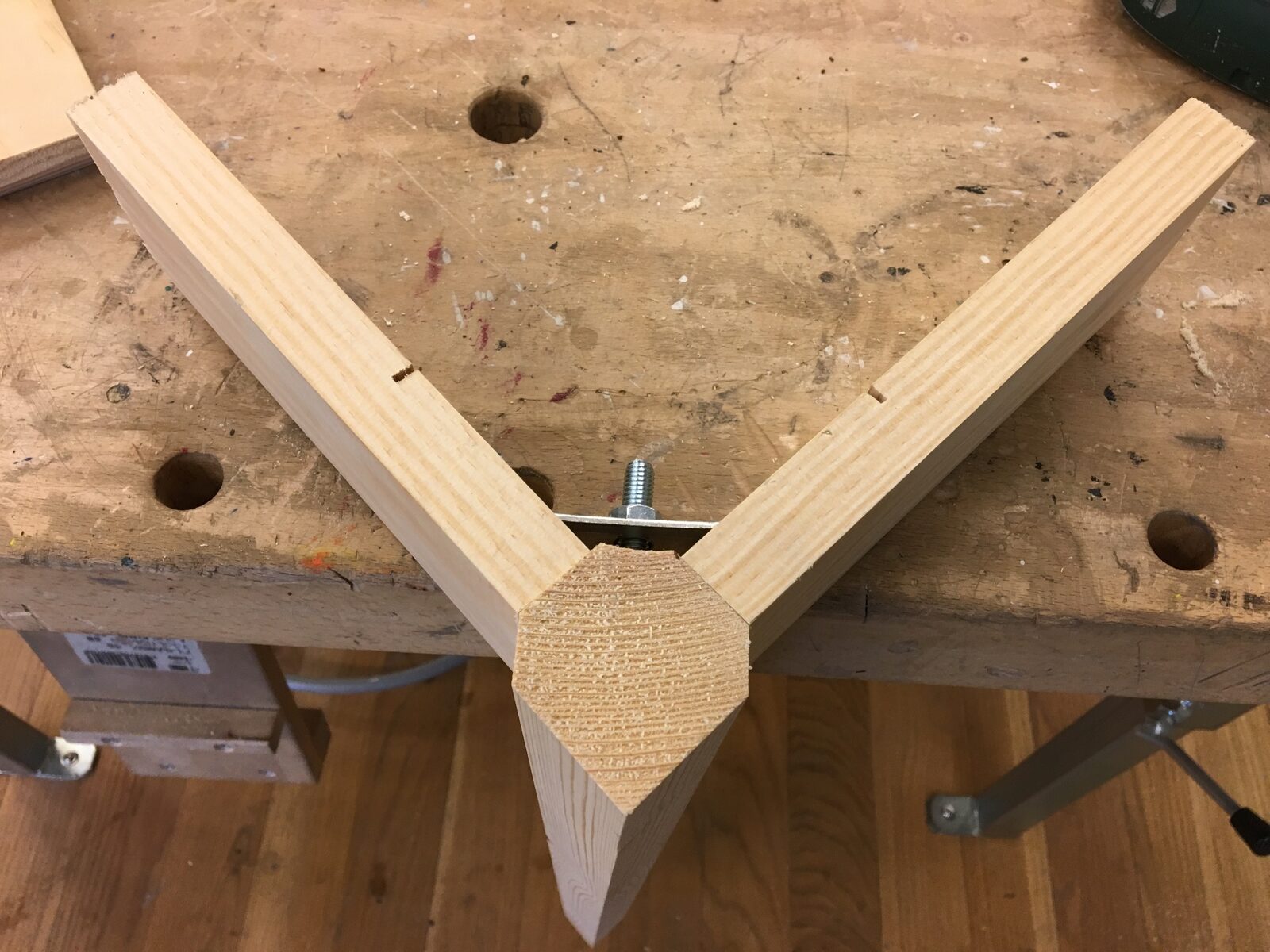 Detaljbild av en handgjord trekantig möbelfog i furu