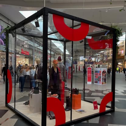 Glasmonter i galleria med röda dekorbågar i trä som rumsdekor