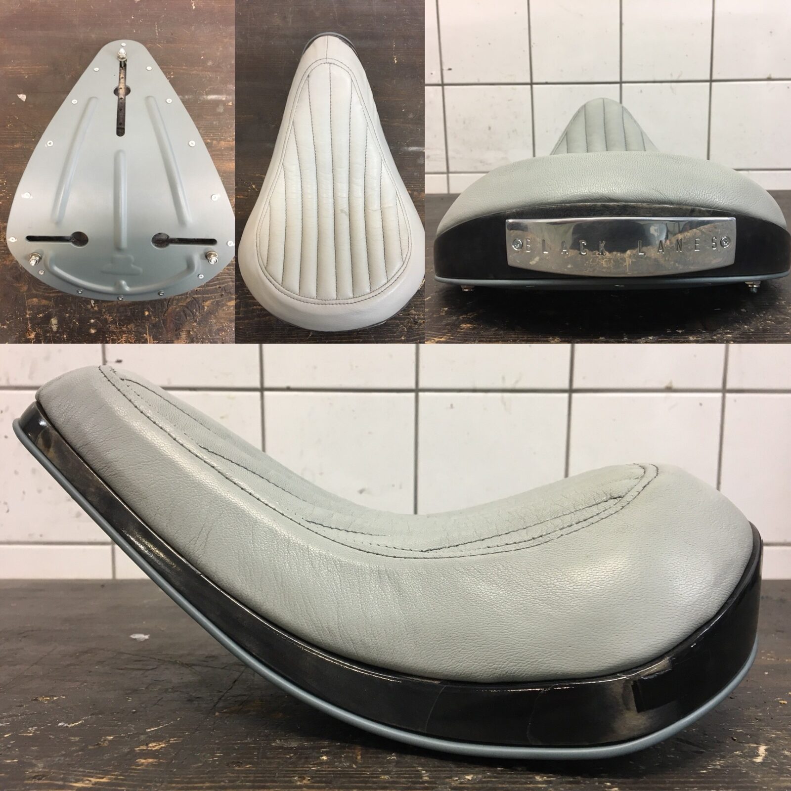 Omklädd motorcykelsadel i ljusgrått skinn med svart kantlist