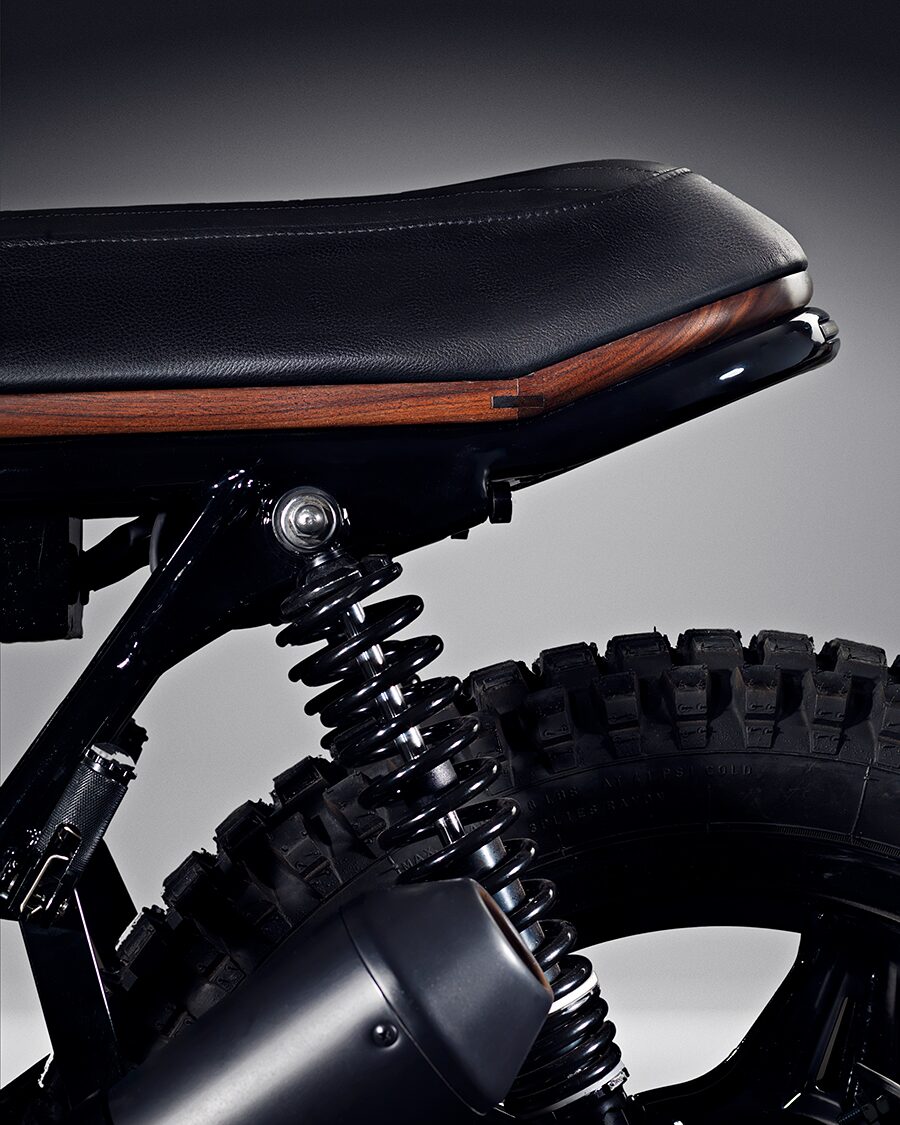 Detaljbild av motorcykelsadel med inlägg av mörkare träslag som list