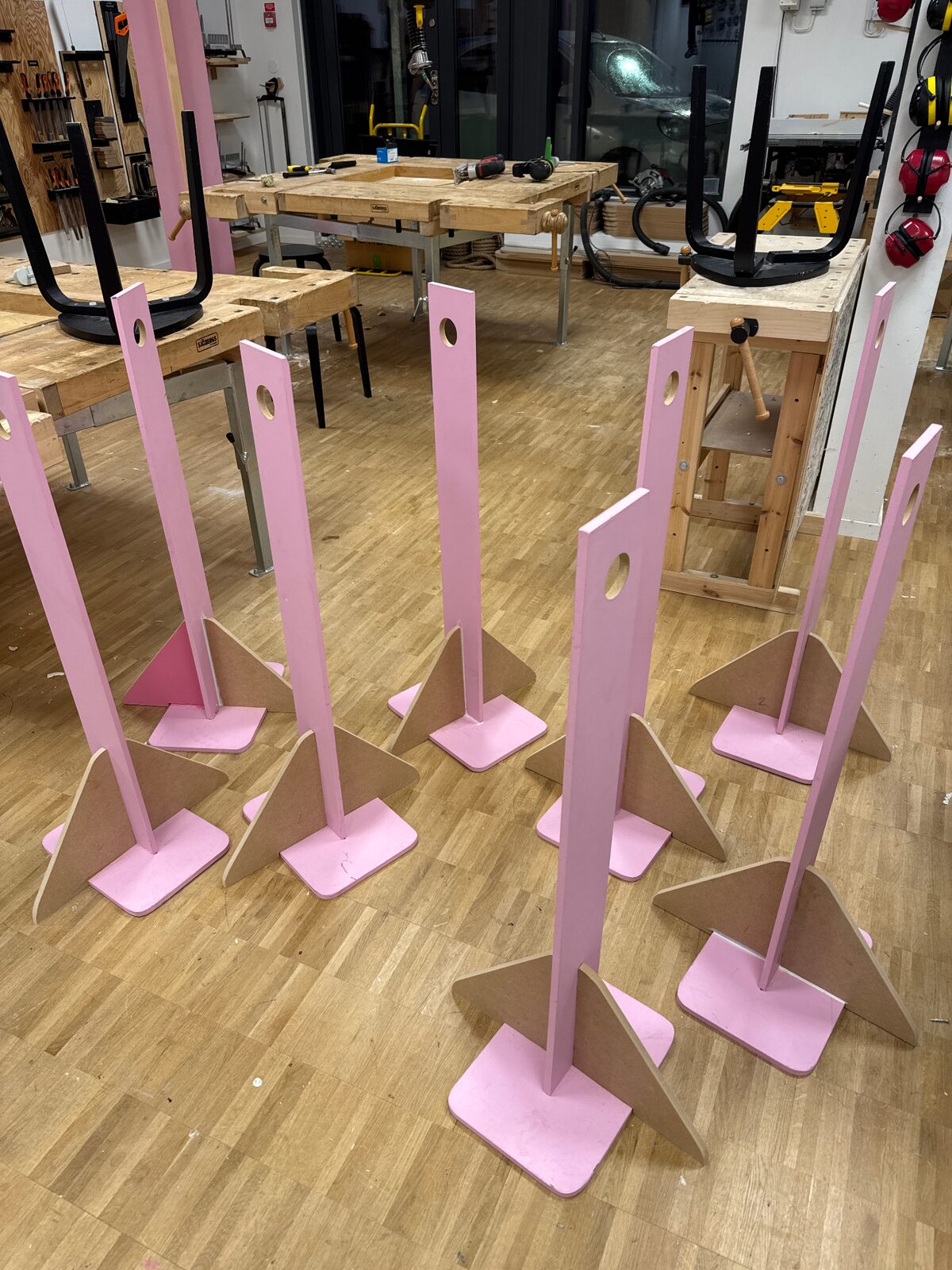 Serie av rosa skyltställ i trä med runda hål, redo för event