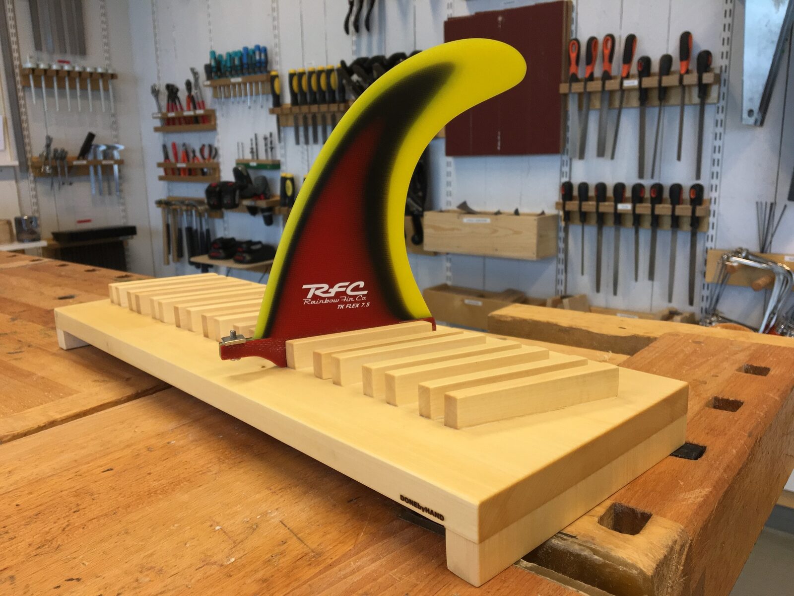 Handgjort displayställ i trä för surfboard-fena