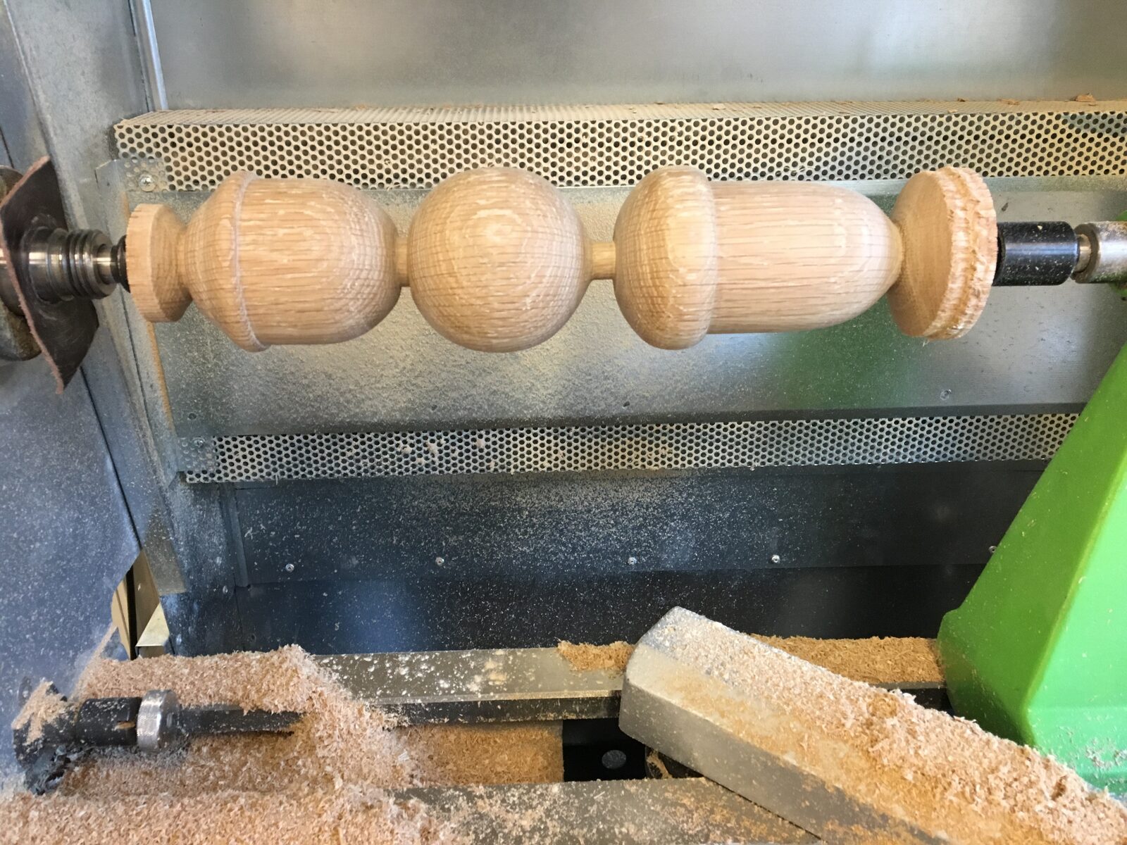 Svarvad trädetalj i ek under arbete i svarven