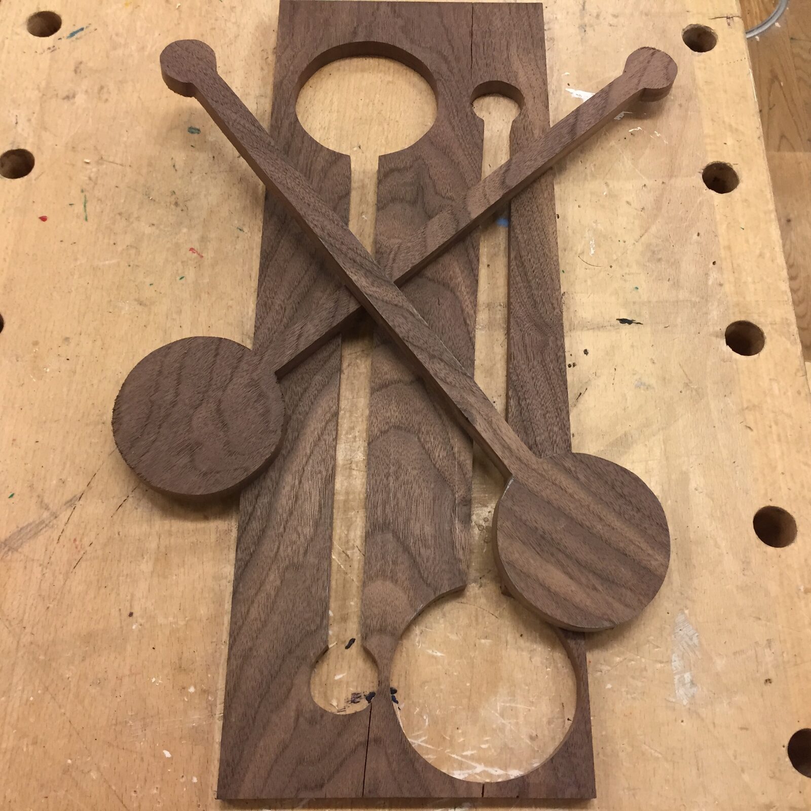 Väggobjekt i valnöt med korsade former och utsågade detaljer