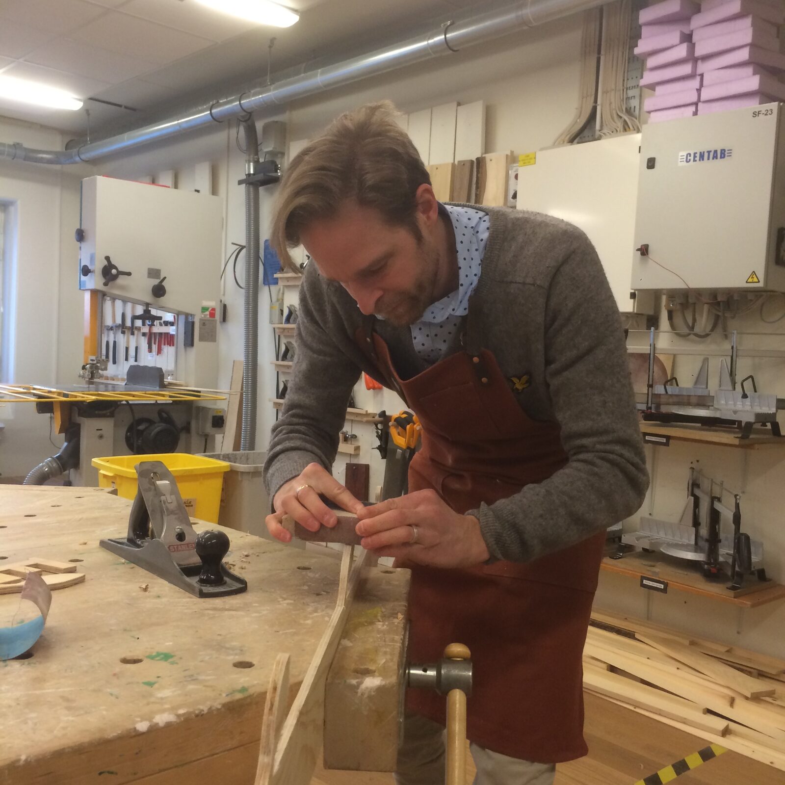 Hantverkaren bakom Done by Hand arbetar med en träbit i verkstaden